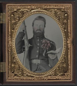 Private David Lowry, of Company E, 25th Virginia Cavalry Regiment, Company A, 41st Virginia Infantry Regiment, and Company D, 47th Virginia Infantry Regiment, in uniform and corsage of flowers with musket and book (between 1861 and 1865; LOC: LC-DIG-ppmsca-32062)