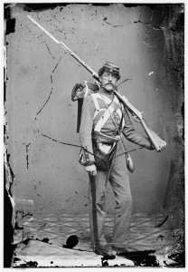 Unknown location. Unidentified Union volunteer with shouldered rifle and bayonet in photographer's studio (Between 1860 and 1865; LOC: LC-DIG-cwpb-04763)