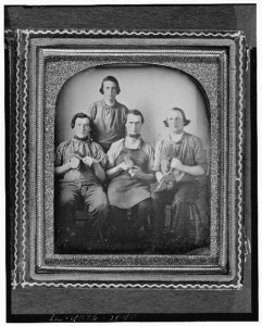 Occupational group portrait of four shoemakers, one full-length, standing, other three seated, holding shoes and shoe making equipment (between 1840 and 1860; LOC: LC-USZC4-3946)