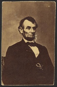 Abraham Lincoln, three-quarter length portrait, seated, facing right; hair parted on Lincoln's right side (by Anthony Berger; 1864 Feb. 9, printed later; LOC: LC-DIG-ppmsca-19190)