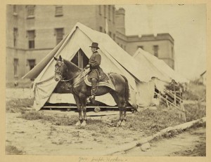 [Major-General Joseph Hooker, full-length portrait, seated on horse, facing left, wearing military uniform, two tents and large building in the background (between 1861 and 1865; LOC: LC-DIG-ppmsca-19394)