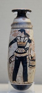 Amazon wearing trousers and carrying a shield with an attached patterned cloth and a quiver. Attic white-ground black-figured alabastron.