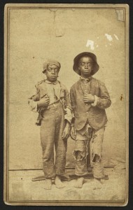 Two African American boys, full-length portrait, facing front] / J. R. Shockley, photographer, West Side of Main St., Hannibal, Mo. (between 1860 and 1865; LOC: http://www.loc.gov/item/2010647915/)