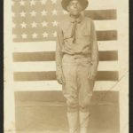World War I soldier with American flag in background (between 1914 and 1918; LOC: https://www.loc.gov/item/2010651602/)