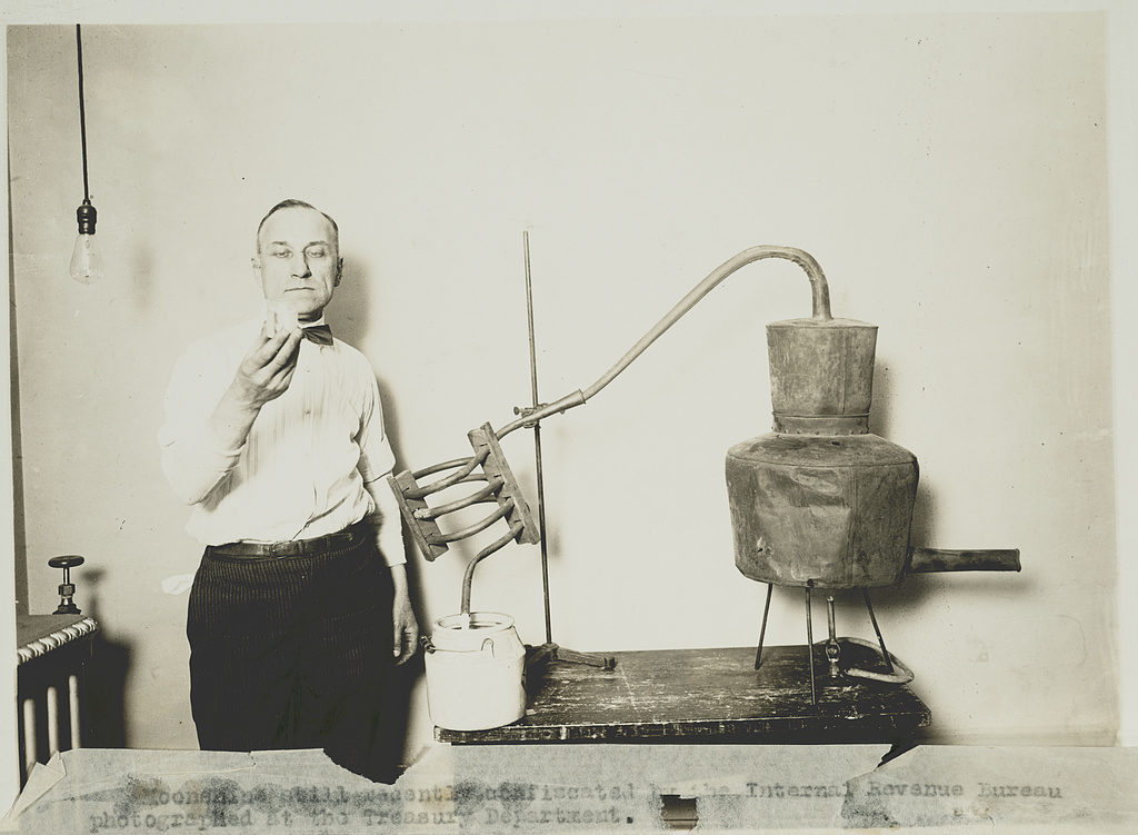 Moonshine still recently confiscated by the Internal Revenue Bureau photographed at the Treasury Department (between 1921 and 1932; LOC: https://www.loc.gov/item/89706121/)