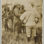 Theodore Roosevelt standing with mostly African men in traditional dress (c1910 April 9. LOC: https://www.loc.gov/item/2010645481/)